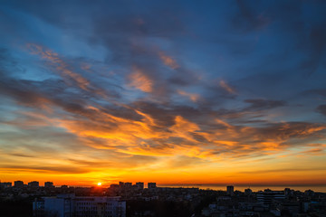 Wall Mural - the morning sun rises over the horizon and turns the clouds golden orange. dawn fire in the sky over