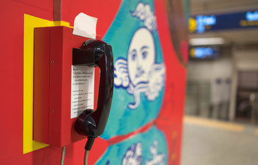 Emergency call on the wall with the blured background at the subway in Bangkok.