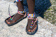 Tribal masai legs with a colorful bracelet and sandals made of car tires, close up. Island of Zanzibar, Tanzania, Africa