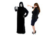 Scared businesswoman paranoid of catching a deadly disease represented by the grim reaper.  She is frightened of contracting a pandemic illness such as coronavirus