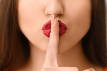 emotional young woman showing silence gesture, closeup