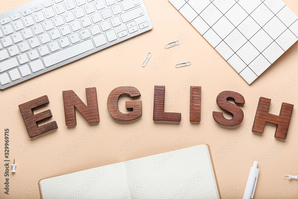 Composition with stationery, PC keyboard and text ENGLISH on color background