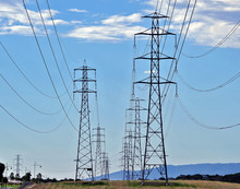 Electric Pylons Or Transmission Towers Crossing The Countryside