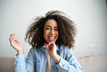 Cheerful African Teenage Girl Blogger Talking To Camera Recording Vlog. Happy Mixed Race Young Woman Laughing Making Video Call At Home. Funny Social Media Influencer Streaming Blog. Webcam View.