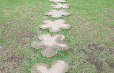 Wall Mural - The path in the garden. Stone walkway on green grass