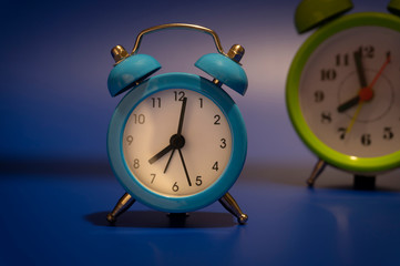 Twin bell analog alarm clocks over blue background