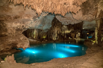 Amazing underground limestone caves. Blue river is under light. Mexican cenotes.  Secret and hidden lake. 