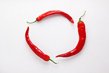 Red Chili Peppers On White  Wood Background. Hot Spicy Food Ingredient. Circle Frame. Top View