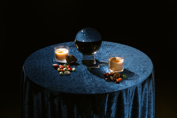 Sticker - Crystal ball, candles and fortune telling stones on dark blue velour fabric isolated on black