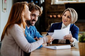 Wall Mural - Smiling financial agent having meeting with her clients at their home.