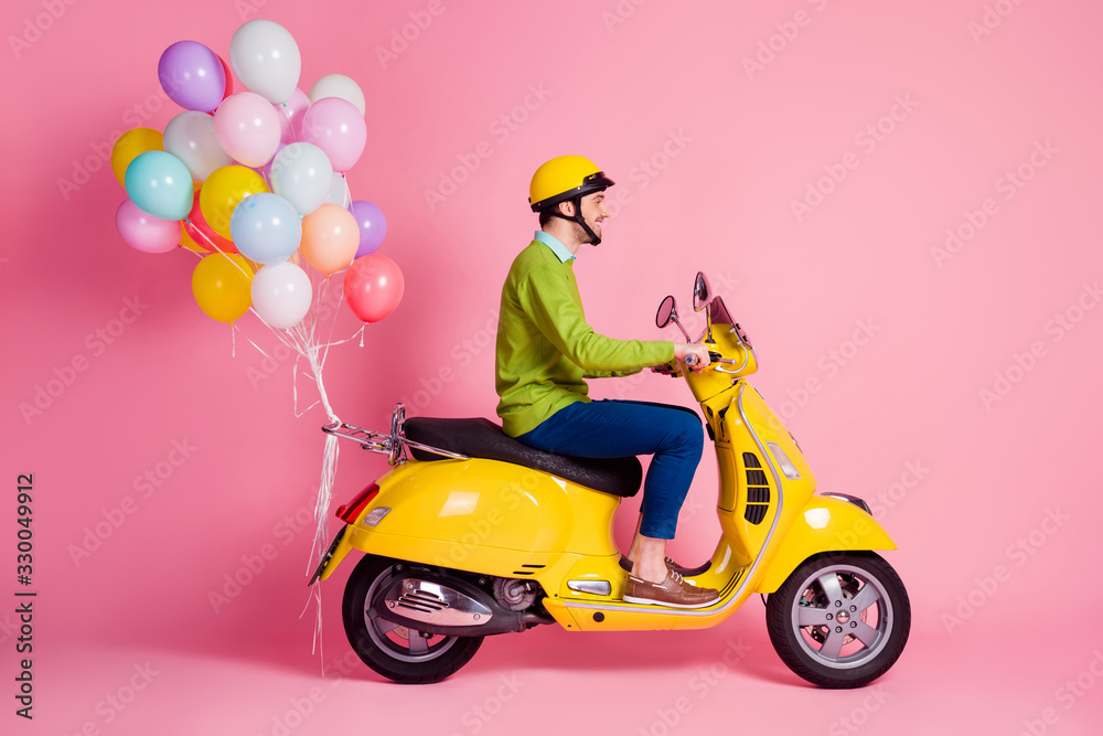 Profile side view of his he nice attractive cheerful cheery glad guy driving moped bringing carrying bunch air balls festive decoration isolated over pink pastel color background - obrazy, fototapety, plakaty 