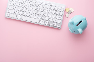 Wall Mural - Piggy bank, computer and coins on pink backgroud