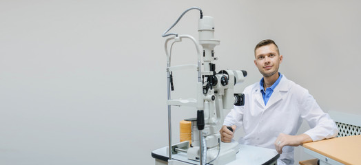 Wall Mural - Young beautiful doctor/eye specialist/optometrist in an ophthalmologic clinic