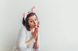 © Юлия Завалишина - Happy Easter holiday celebration spring concept. Young woman wearing bunny ears isolated on white background. Preparation for holiday. Girl looking happy and excited having fun on Easter day