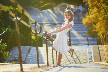 Sticker - Woman in white dress walking on famous Montmartre hill in Paris, France at early morning