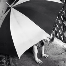Toddler Peeks Out From Below An Umbrella