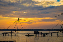Sunset From Kumbalangi's Beautiful Backwaters. He Fishing Nets Portray The Life Of People Living Around The Coastal Areas.