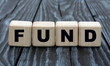 concept word fund on cubes on a dark wooden background