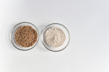 Wall Mural - spelt grain seeds heap in glass bowl and powder  on white background