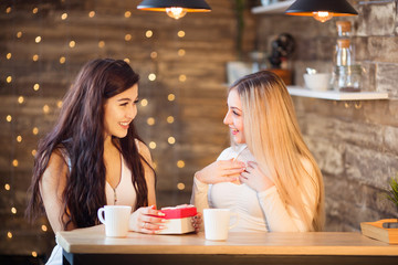 two beautiful young women are sitting at the table