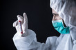 medico con tuta protettiva e mascherina tiene in mano una provetta per il test del sangue del coronavirus -   sfondo nero
