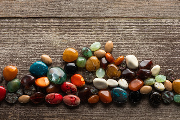 Wall Mural - Top view of colorful fortune telling stones on wooden surface