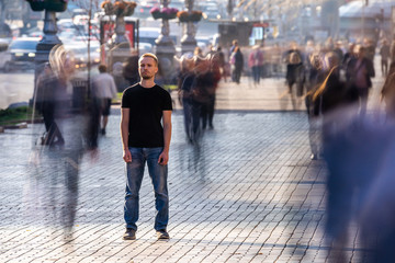 The man stands on the crowded street