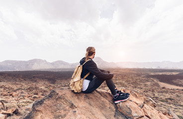 Wall Mural - woman alone sitting on the mountain looking at the sun valley.