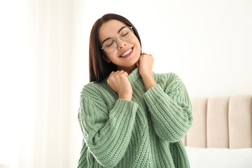 Canvas Print - Young woman wearing warm sweater on bed at home. Winter season