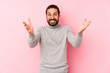 © Asier - Young long hair man isolated on a pink background receiving a pleasant surprise, excited and raising hands.