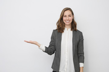 beautiful businesswoman is looking happy and presenting your product