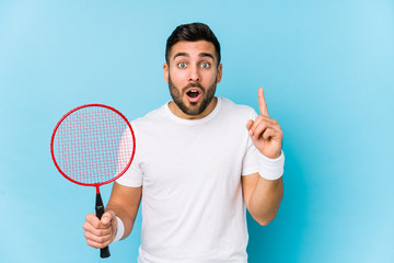 Wall Mural - Young handsome man playing badminton isolated having some great idea, concept of creativity.