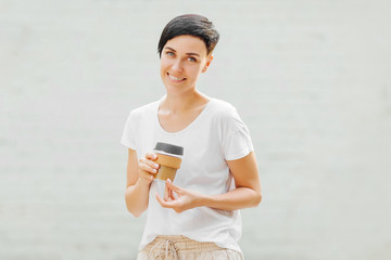 Wall Mural - Young woman  holding reusable coffee mug.  Sustainable lifestyle. Eco friendly concept.