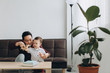 © anatoliycherkas - Asian dad and his cute little son playing with a wooden plane in a bright room