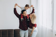 © anatoliycherkas - Young asian dad and european blonde mom hold son in her arms in bright room. Multicultural trendy concept
