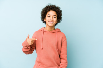 african american little boy isolated person pointing by hand to a shirt copy space, proud and confid