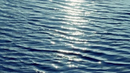 Wall Mural - Beautiful top view of the waves in the ocean. Bright reflection of the sun on the surface of the water. A unique game of light, glare of light in reflection and refraction waves. looped