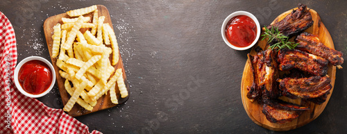 Fotomural Grilled pork ribs with rosemary and french fries, top view