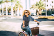 © simona - Beautiful and cheerful adult young woman enjoy bike ride in sunny urban outdoor leisure activity in the city - happy people portrait - trendy female outside having fun