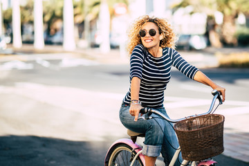 beautiful and cheerful adult young woman enjoy bike ride in sunny urban outdoor leisure activity in 