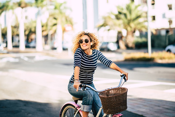beautiful and cheerful adult young woman enjoy bike ride in sunny urban outdoor leisure activity in 