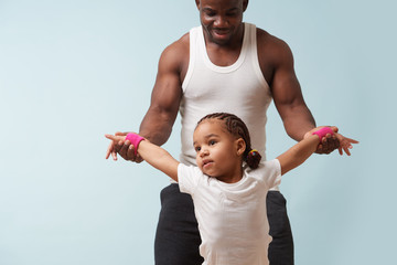 Wall Mural - Father helping his little daughter to stretch at home