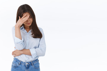 Wall Mural - Oh gosh dont look at me. Embarrassed annoyed brunette female hiding her face with facepalm, look down trying avoid eye contact with her ex boyfriend acting stupid and embarrassing, white background