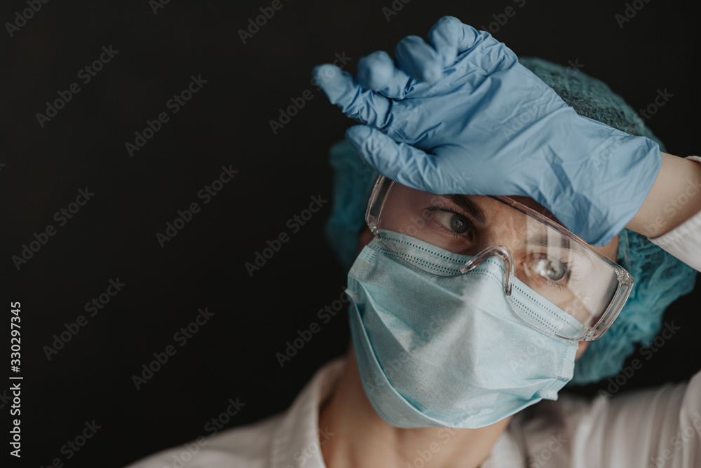 tired medical worker doctor after taking a large number of patients due to the epidemic of coronavirus - obrazy, fototapety, plakaty 