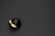Two halves of a black apple on the matte black background. Minimal style. Conceptual minimalist black art. Matte surface. Cut fruit. One. Space for text