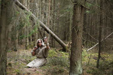 A man in a cassock spends a ritual in a dark forest