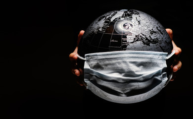 Wall Mural - hands of little child holding globe sphere, planet map covered with medical protective mask isolated