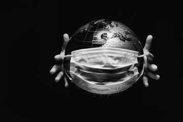 hands of little child holding globe sphere, planet map covered with medical protective mask isolated