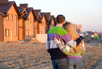 Wall Mural - Rear view of young couple looking at their new house.