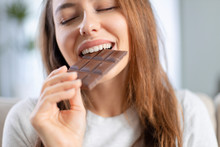 Woman Biting A Chocolate Bar